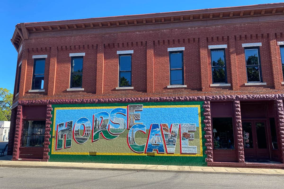 Mural on side of red brick building saying "Horse Cave."
