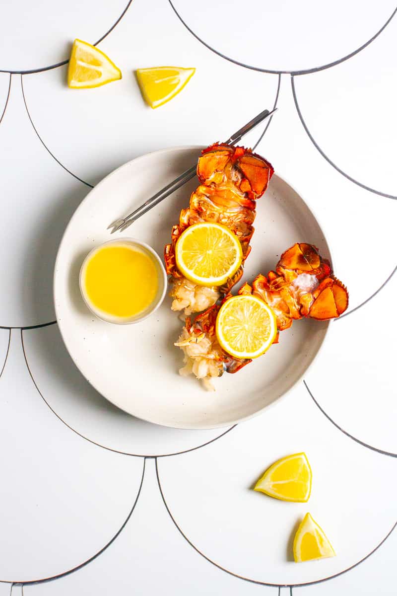 broiled lobster tails in a serving dish with butter.