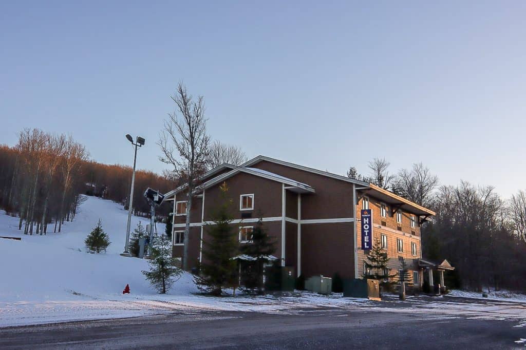 Timberline Hotel, a brown three-story building in front of snowy hill.