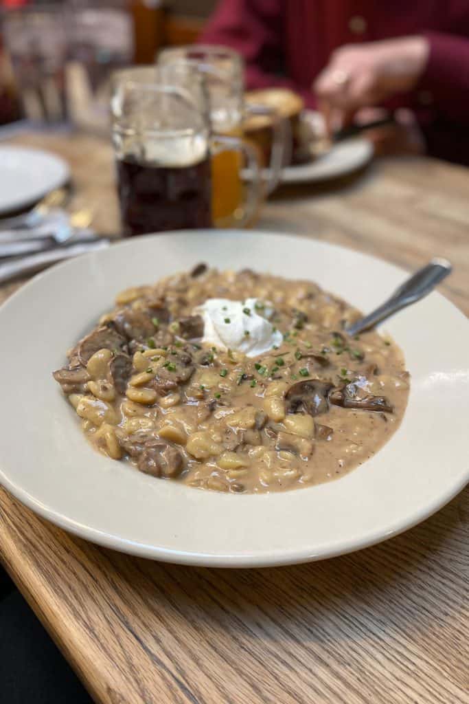 Steak jager spatzle, a beef dish with mushrooms and a creamy sauce, topped with sour cream.