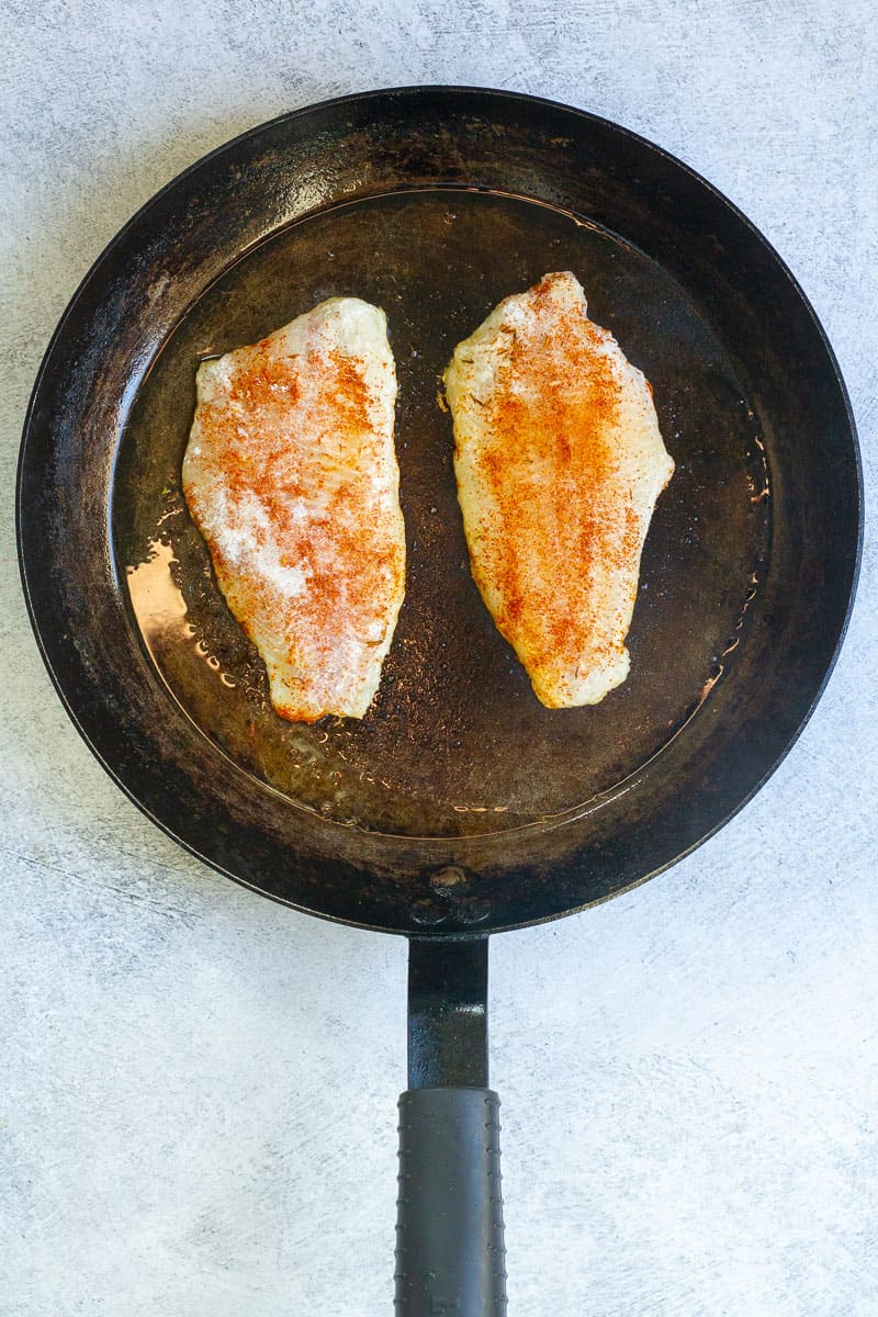 Seasoned fish in a pan.