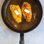 catfish topped with butter in a pan