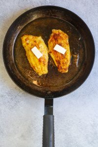 catfish topped with butter in a pan
