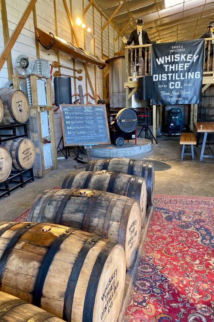 Whiskey barrels with mash bill listed on chalkboard.