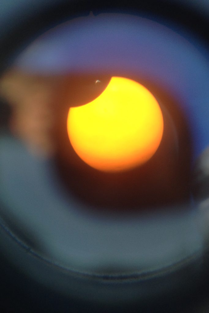 View of sun with moon beginning to cross in front.