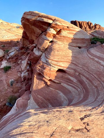 Rocky outcropping with wave-like red and white striping.