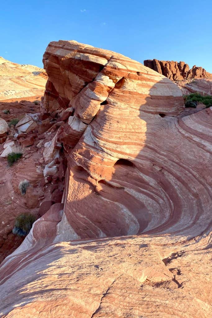 Rocky outcropping with wave-like red and white striping.