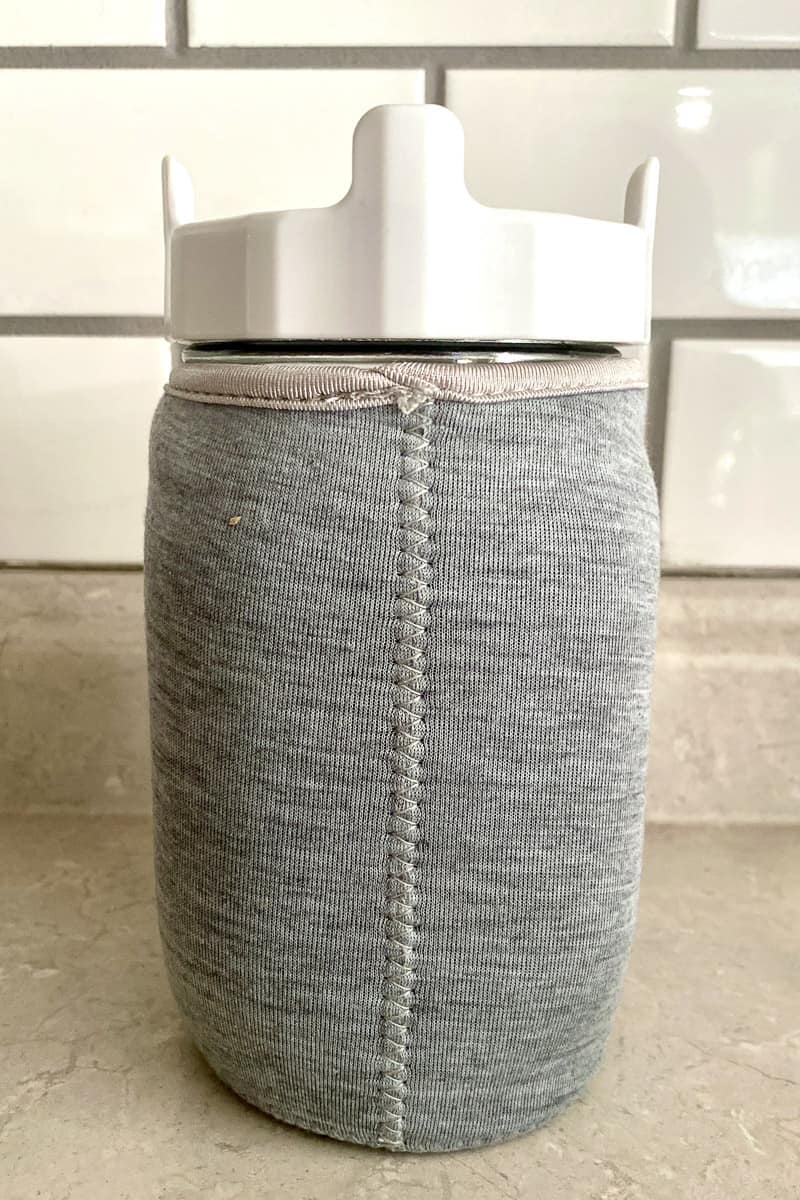 Jar covered with fabric sleeve.