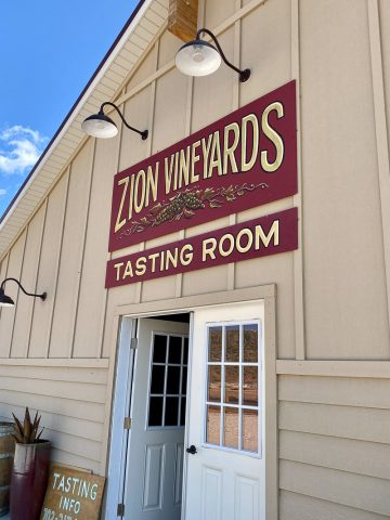 Doors with overhead sign for Zion Vineyards tasting room.