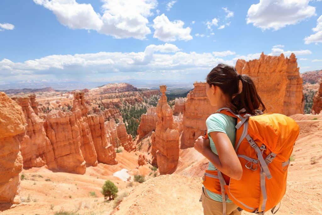 Woman with backpack looking out over view of Bryce Canyon.