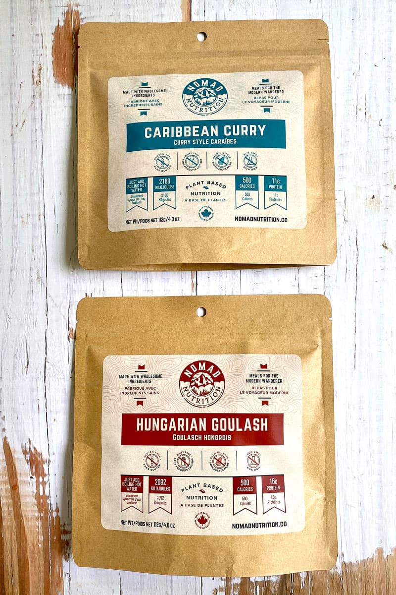 Dehydrated meals of Caribbean Curry and Hungarian Goulash from Nomad Nutrition in brown paper packages.