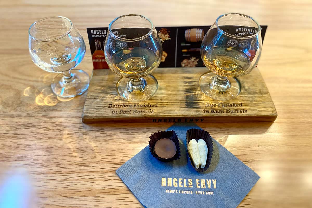 Flight of bourbon samples and two candies on napkin.