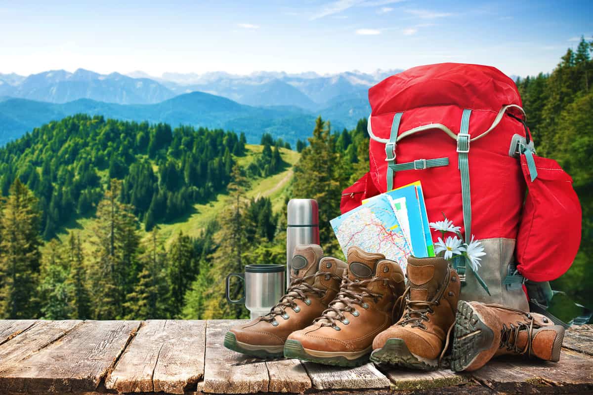 Backpack, hiking boots, and thermos that can be considered when figuring out how to pack for backpacking when flying.