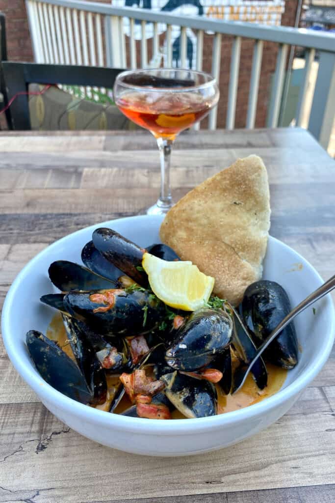 Creole Mussels with chunk of bread and lemon slice.