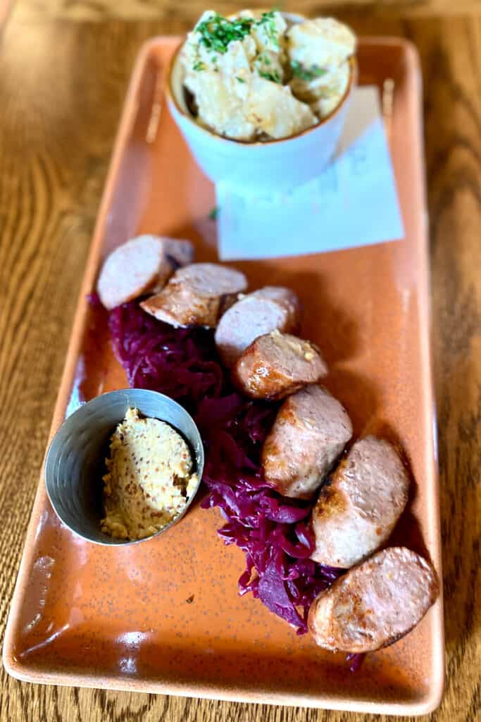 Brewmasters sausage with red sauerkraut and potato salad.