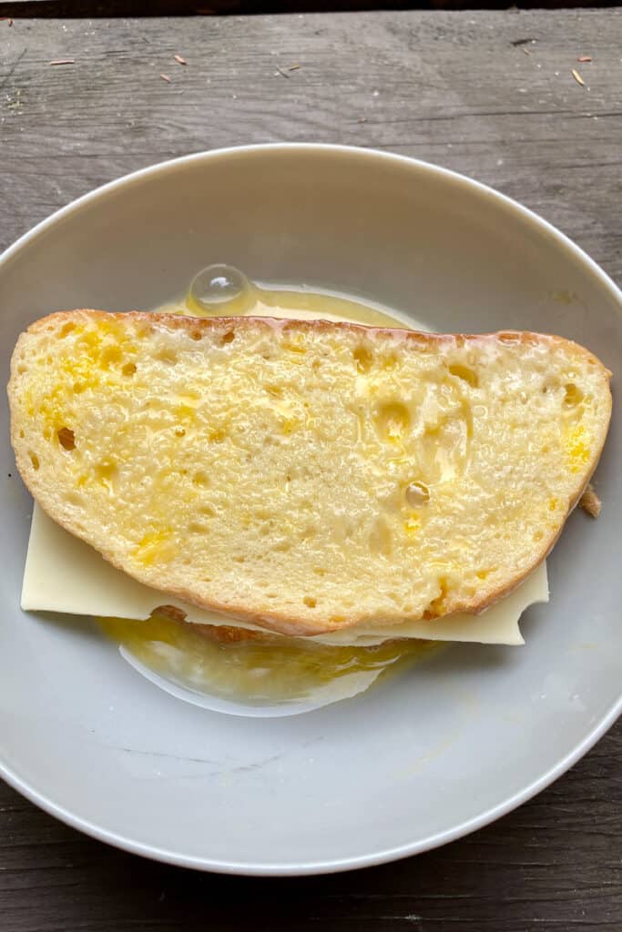 Sandwich dipped in bowl of egg mixture.