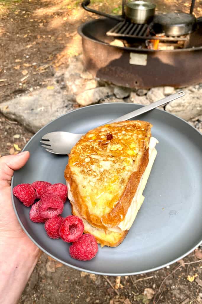 Campfire Monte Cristo sandwich on plate with raspberries.