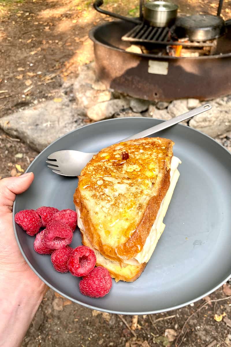 Campfire Monte Cristo sandwich on plate with raspberries.