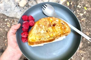 Campfire Monte Cristo sandwich on plate with raspberries.