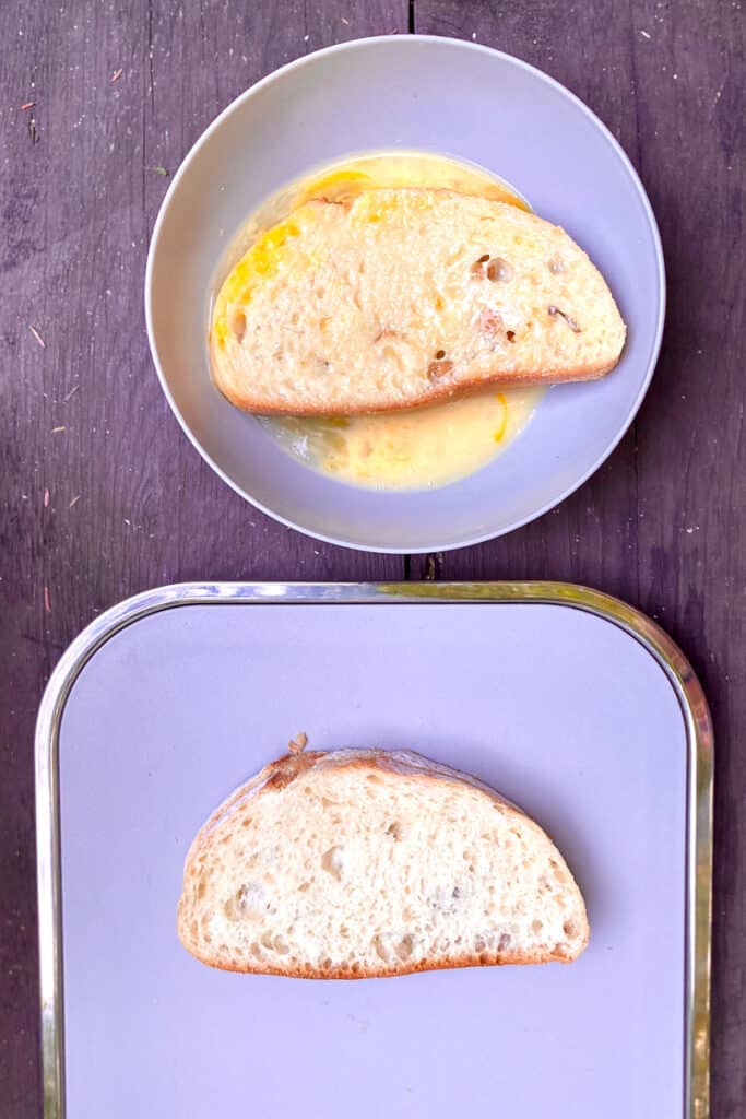 Slice of bread dipped in bowl of egg mixture.