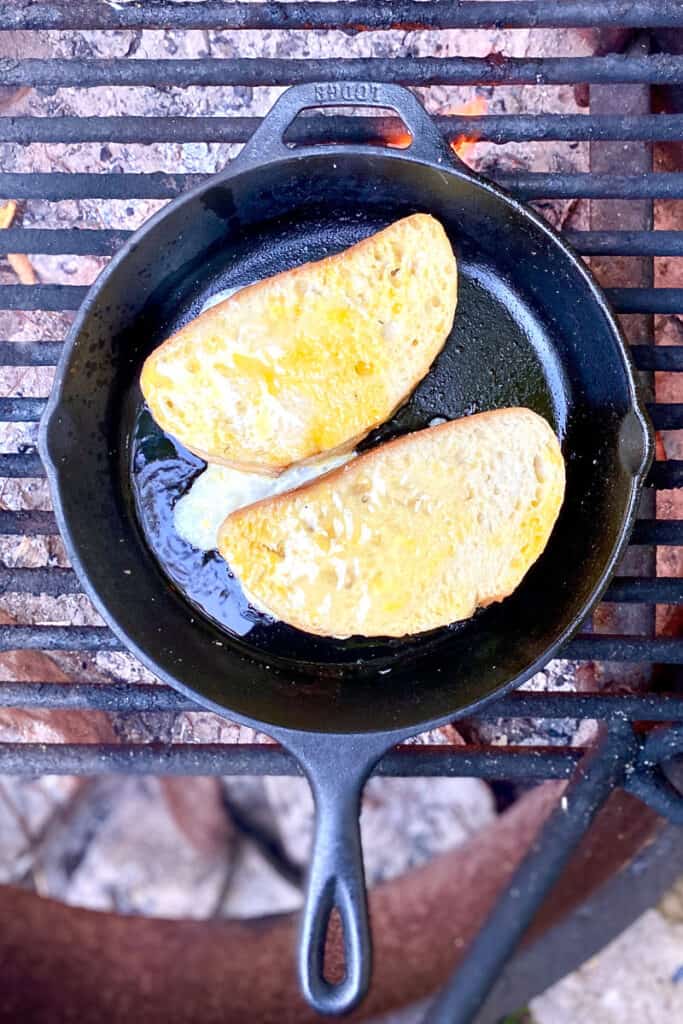 Peanut butter and jelly French toast in cast iron pan over campfire.