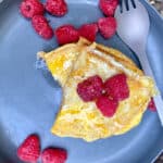 Peanut butter and jelly French toast on plate with raspberries.