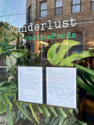 Window with menu posted and sign for Wanderlust CreativeFoods.
