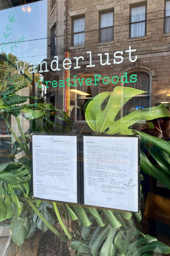 Window with menu posted and sign for Wanderlust CreativeFoods.