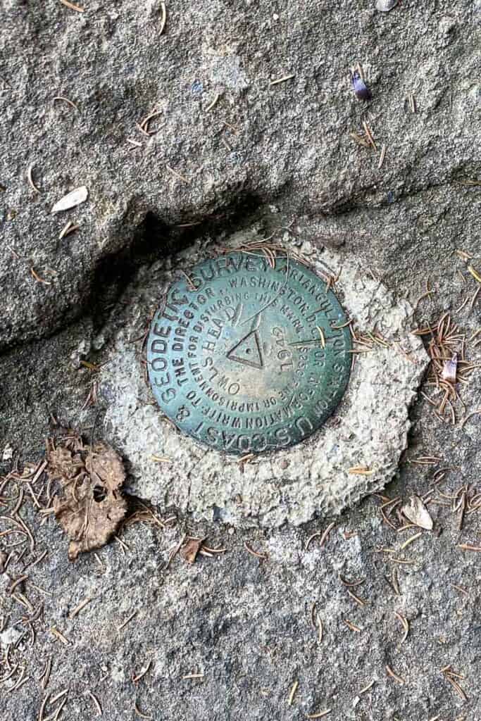 Plaque embedded in rock marking Owls Head Mountain summit.