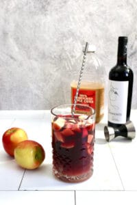 Apple slices, cider, Grand Marnier, and wine in glass.