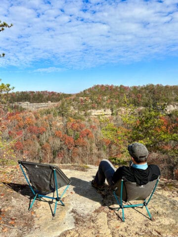 Hiker resting in camp chair at scenic overlook in Red River Gorge.