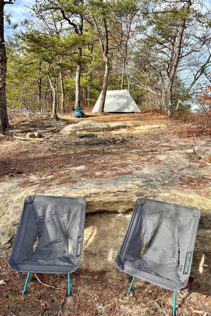 Two camp chairs with pitched tent in background for backpacking in Red River Gorge.