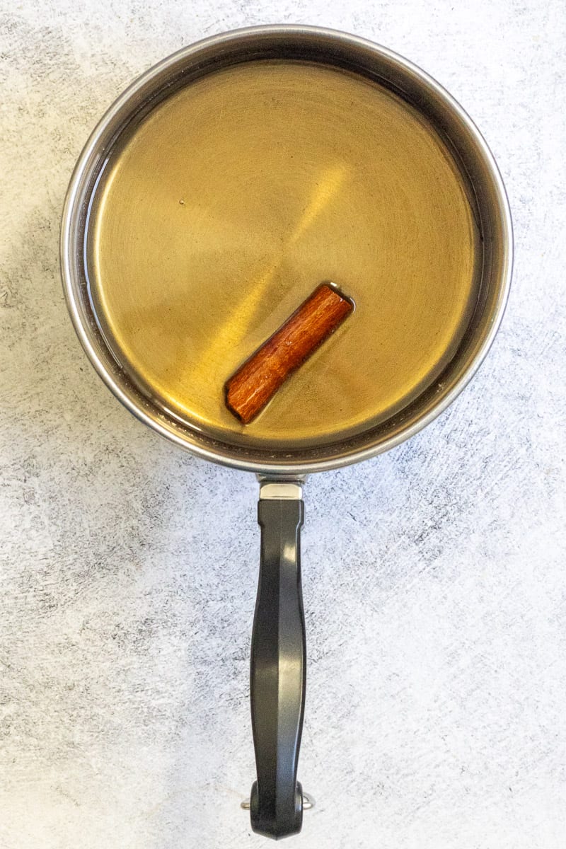 simple syrup with a cinnamon stick in a pot.