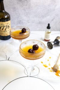 cocktails with cherry garnishes in coupe glasses.
