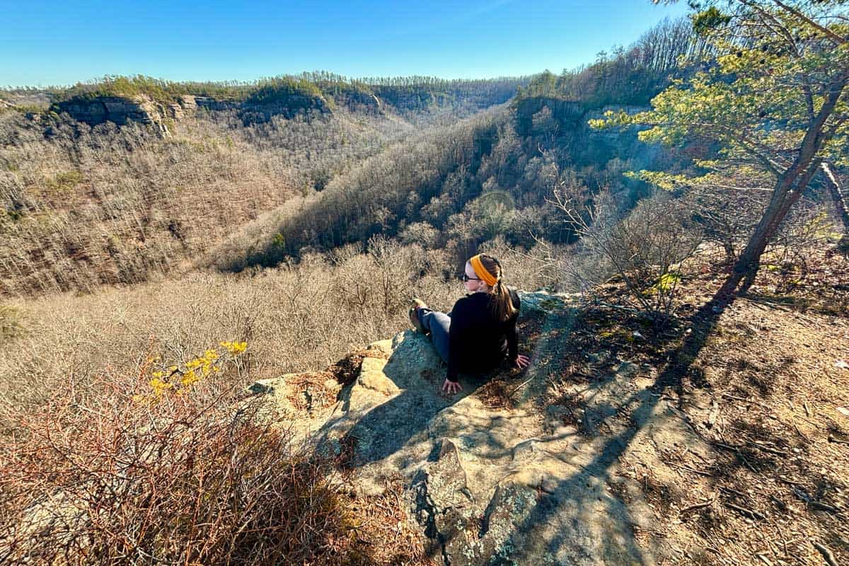 Woman seated at rocky overlook viewing gorge.