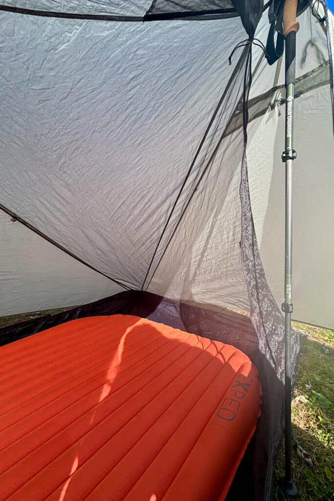 Exped sleeping pad inside tent held up on one side with trekking pole.
