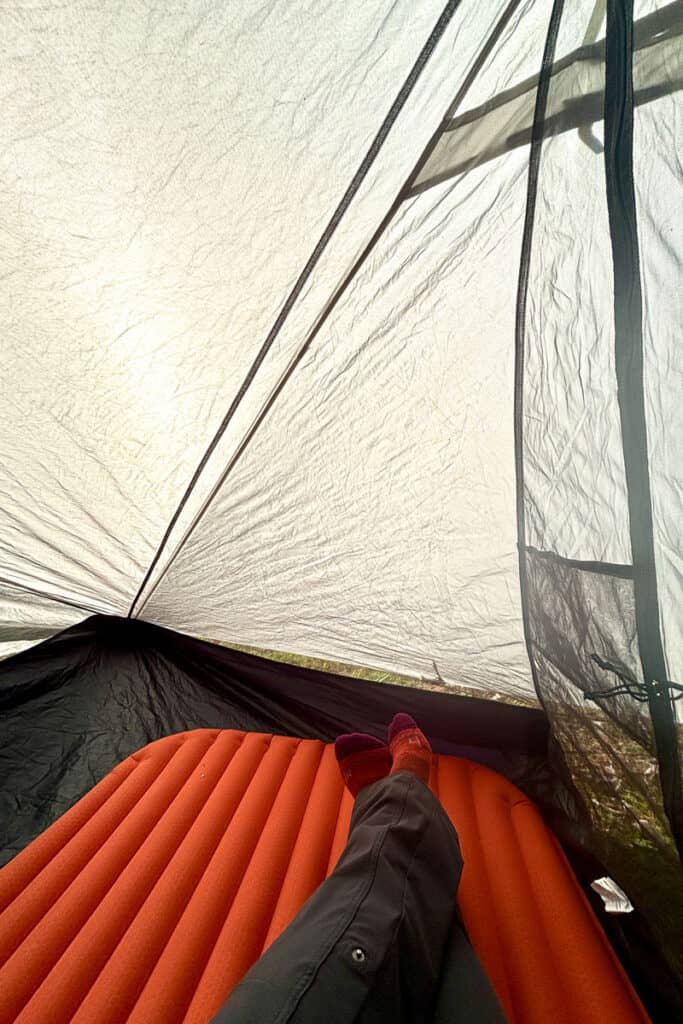 Reclining on sleeping pad inside tent.