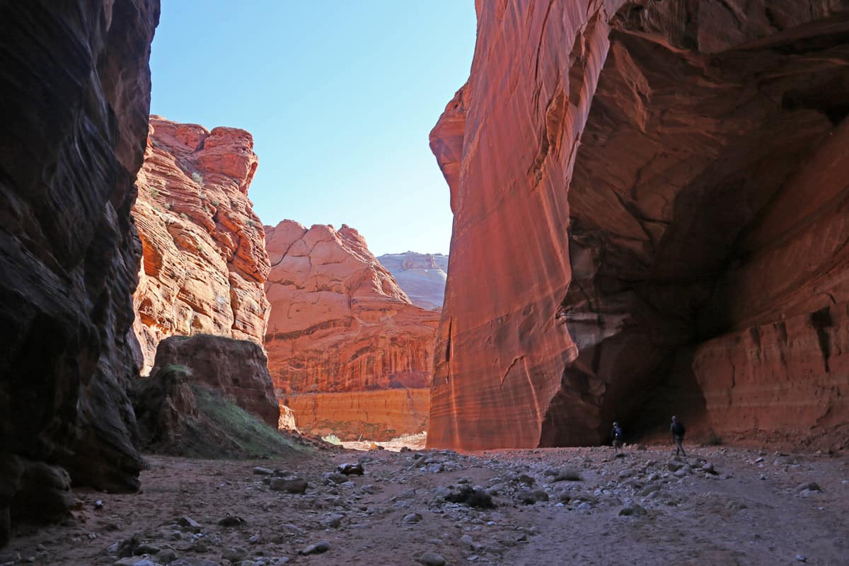 Two hikers in Wire Pass slot canyon right before it converges with Buckskin Gulch. (in the background) Buckskin Gulch, located in southern Utah, it is one of the longest slot canyons in the world.