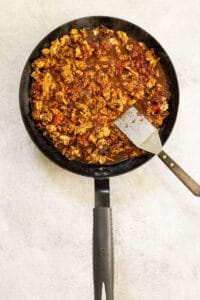 Taco meat with tomatoes in skillet.