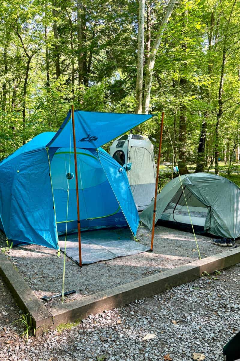 Tents set up with shower tent in background as a way to do tent glamping.