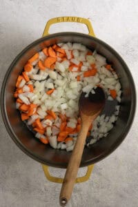 Onions and carrots in soup pot.