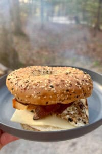 Campfire breakfast sandwich with cheese, bacon and egg on bagel.