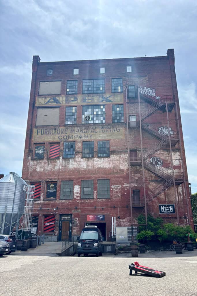 Aged five-story brick building with exterior staircase and faded paint.