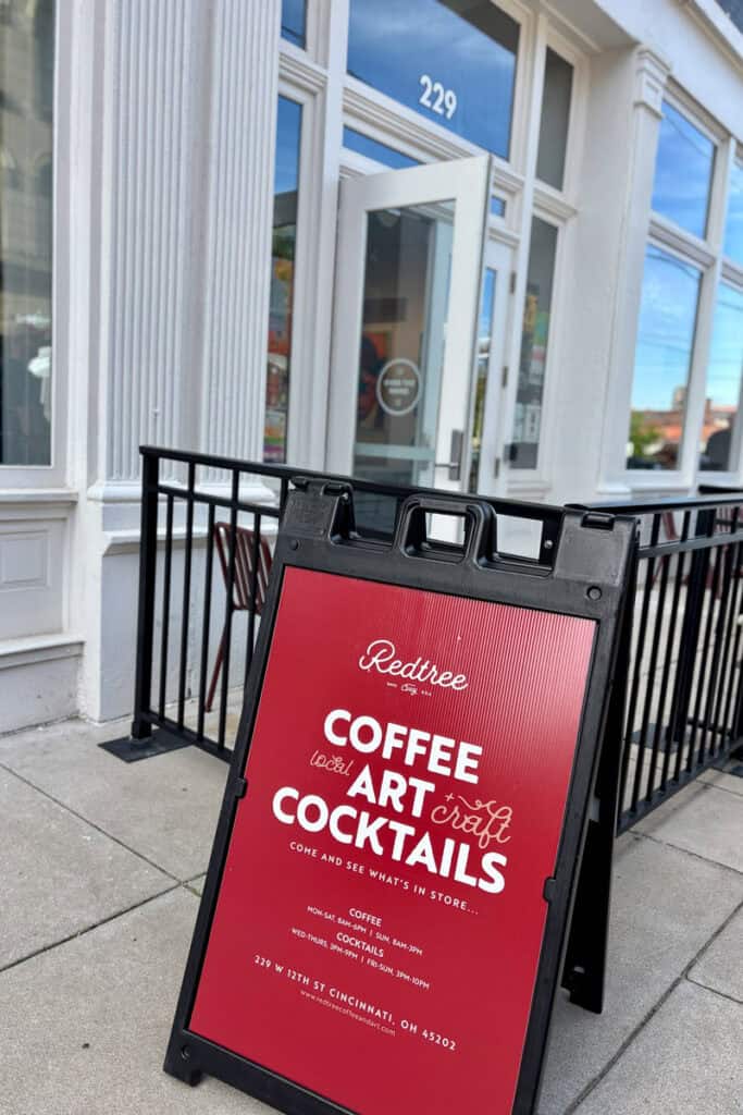 Sign standing on sidewalk for Redtree coffee, art and cocktails.