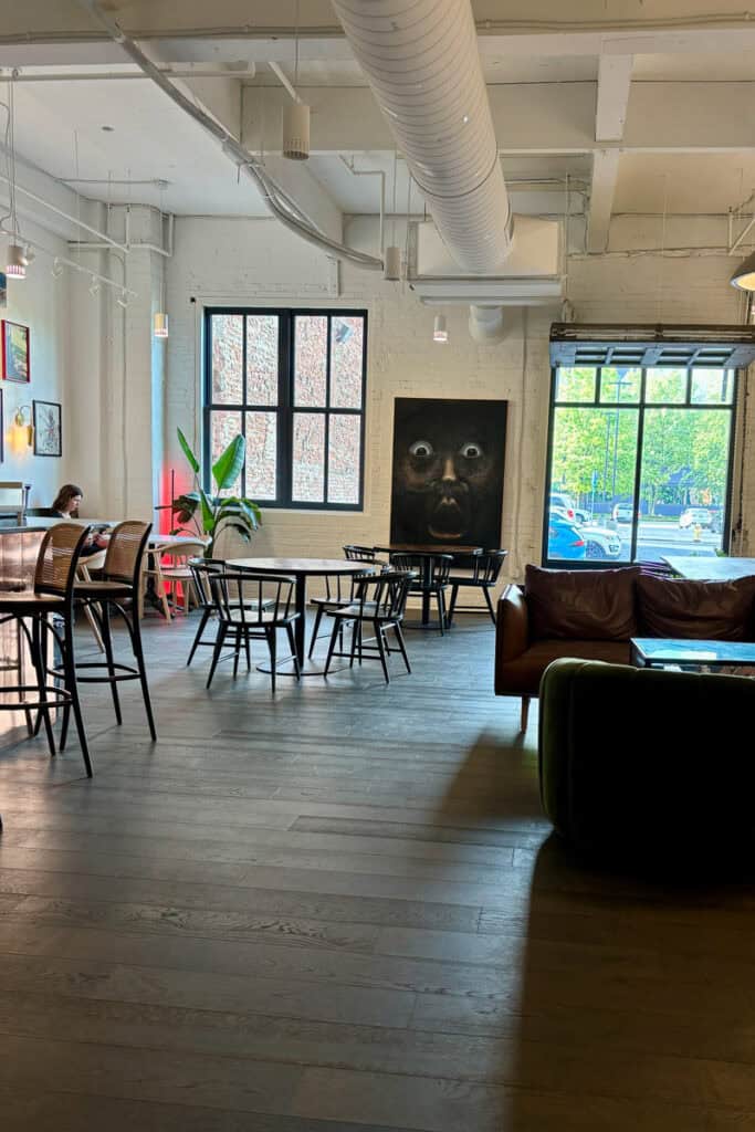 Tables and chairs and sofas in indoor dining area at Redtree Coffee.