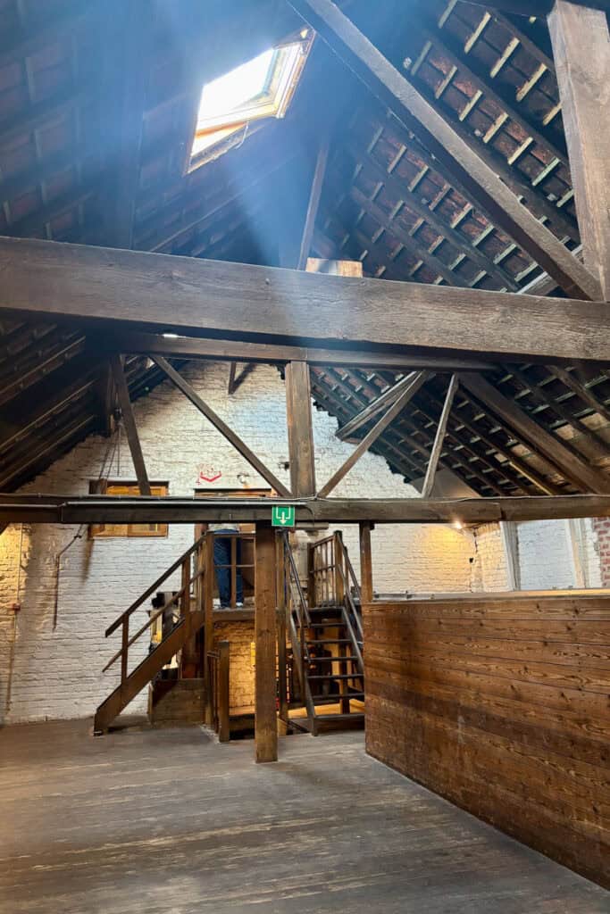 Open area with wooden floor and staircases leading up to platform.