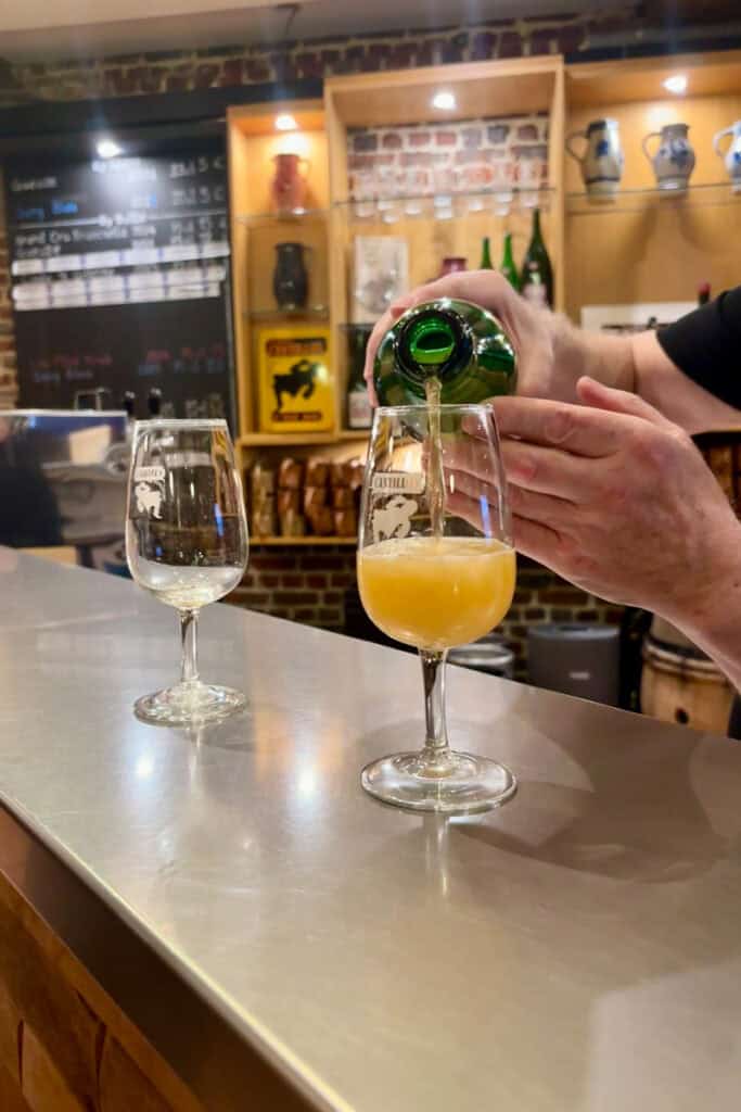 Bartender pouring beer into glass at Cantillon Brewery.