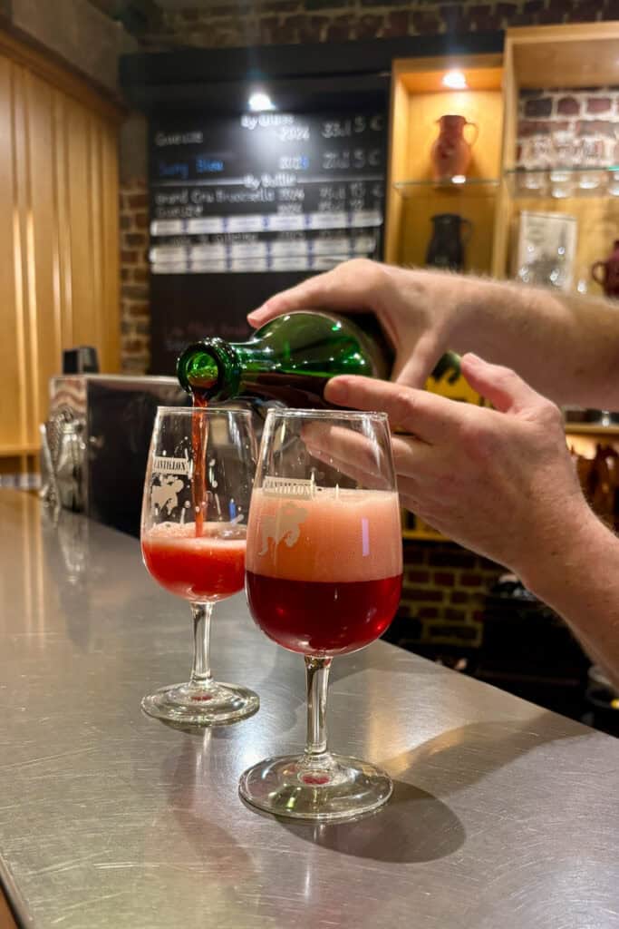 Glass of lambic beer with thick layer of foam.