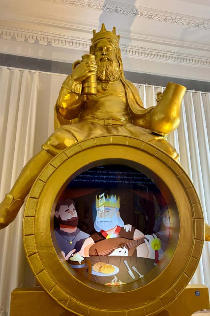 Golden monument to "king of beer" with animated video playing on embedded screen.