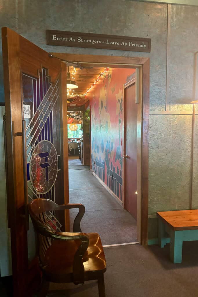 Doorway into dining area with large colorful sunflower mural visible in hallway.